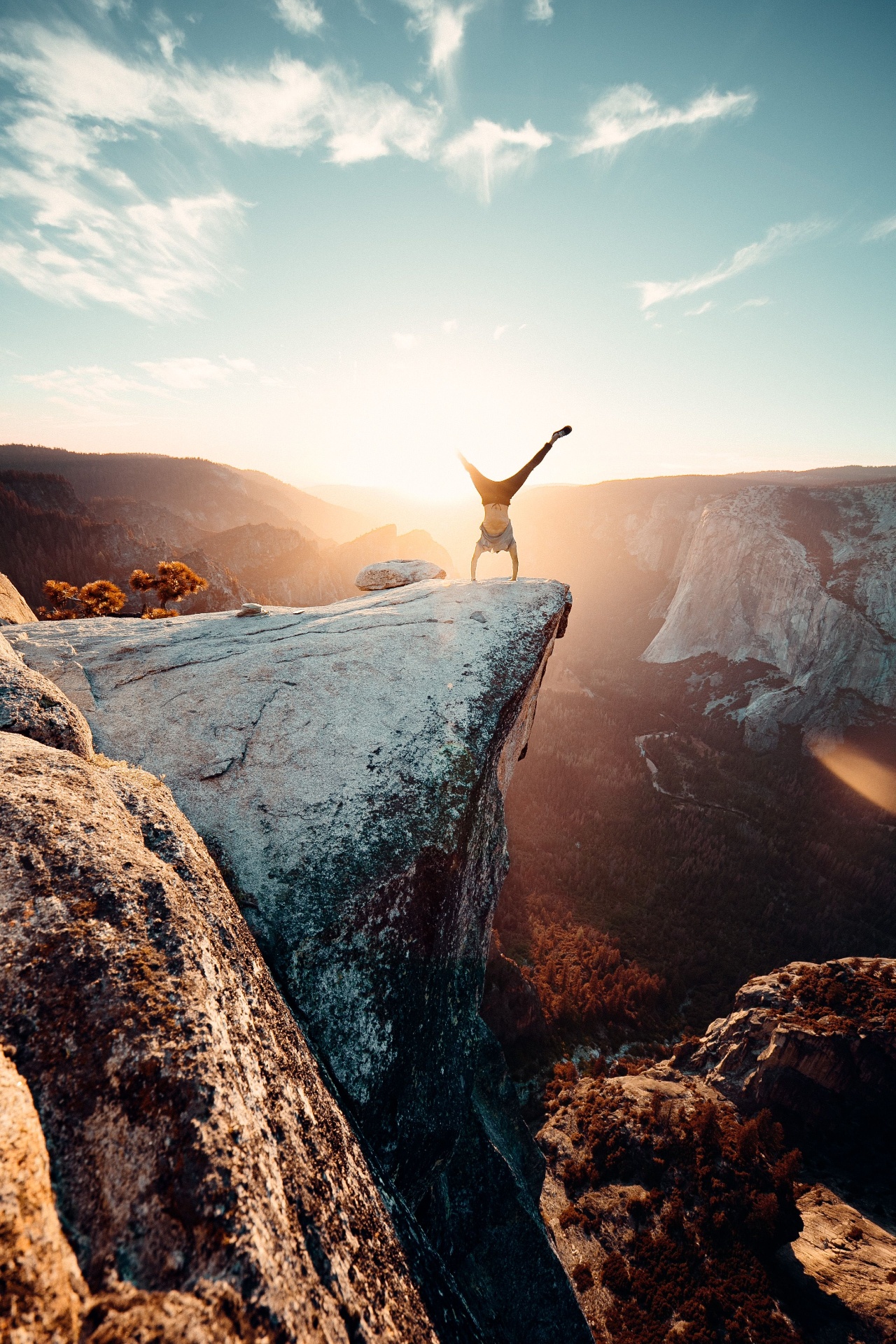 A figure balancing on a sunlit cliff edge — symbolic of trust, courage, and spiritual ascent.